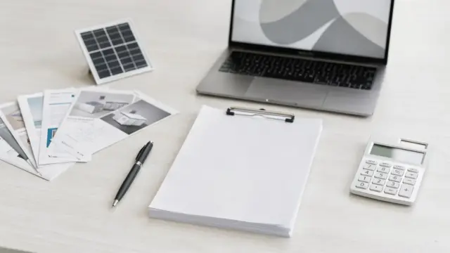 PV-Vertrag prüfen: Vertragsunterlagen, Stift und Solar-Modell auf einem Schreibtisch