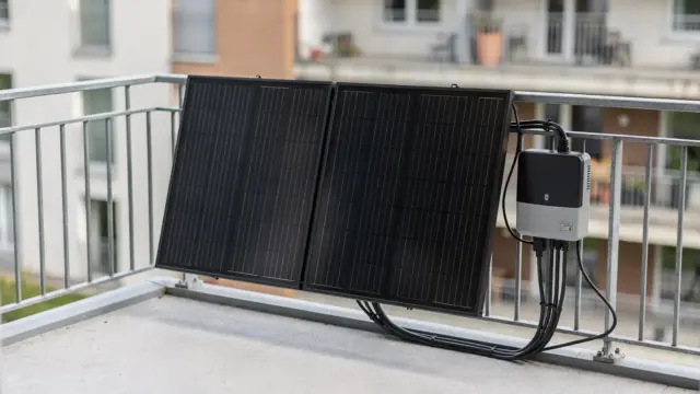 Balkonkraftwerk auf einem Balkon mit zwei Solarmodulen und Wechselrichter