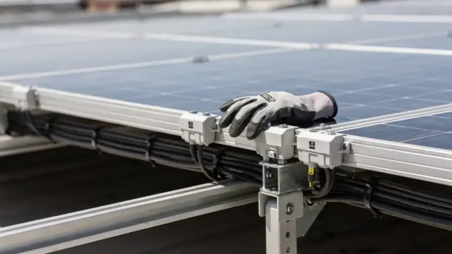Techniker prüft Photovoltaikanlage auf dem Dach bei der Wartung